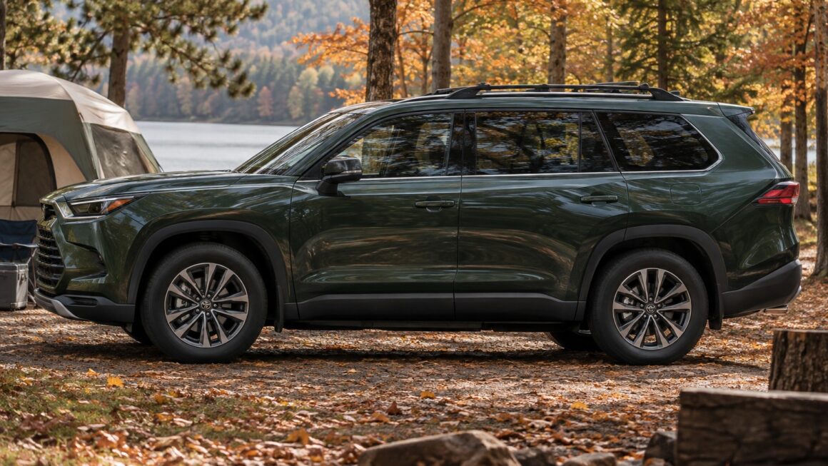 Green Toyota Grand Highlander three-row SUV parked at an autumn campsite